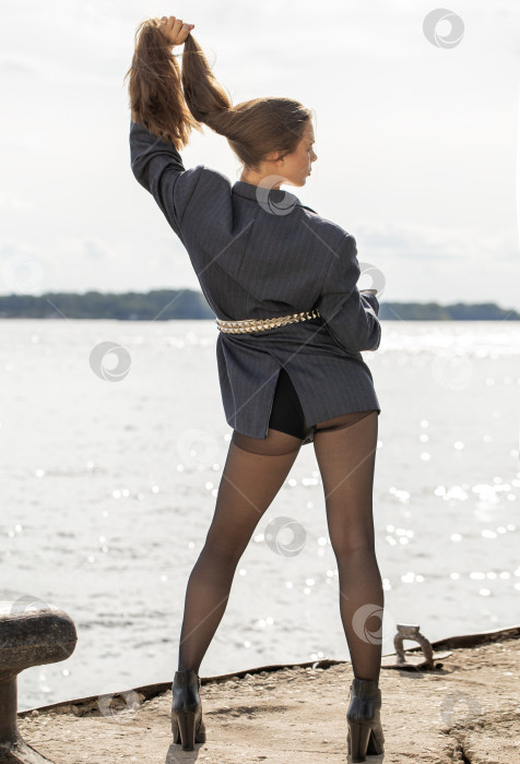 Скачать Портрет молодой брюнетки в полный рост в строгом пиджаке и черных колготках фотосток Ozero