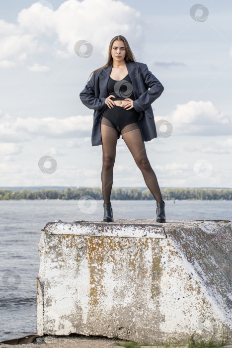 Скачать Портрет молодой брюнетки в полный рост в строгом пиджаке и черных колготках фотосток Ozero