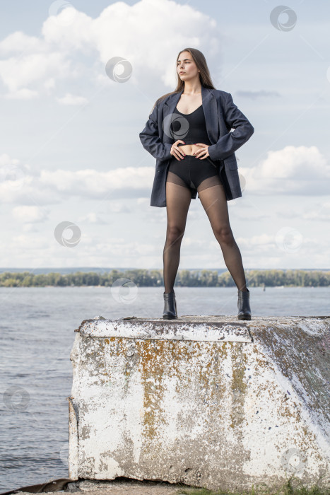 Скачать Портрет молодой брюнетки в полный рост в строгом пиджаке и черных колготках фотосток Ozero