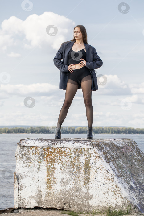 Скачать Портрет молодой брюнетки в полный рост в строгом пиджаке и черных колготках фотосток Ozero