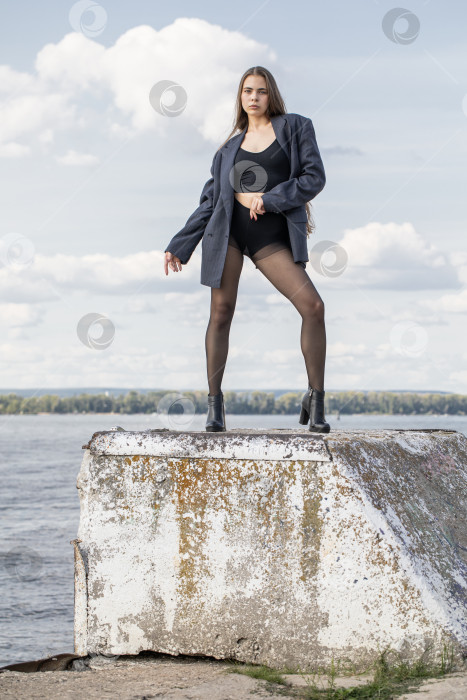 Скачать Портрет молодой брюнетки в полный рост в строгом пиджаке и черных колготках фотосток Ozero