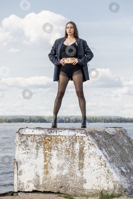 Скачать Портрет молодой брюнетки в полный рост в строгом пиджаке и черных колготках фотосток Ozero