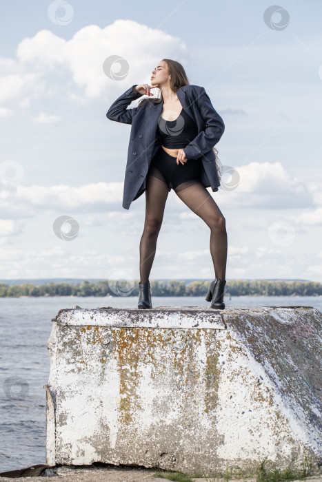 Скачать Портрет молодой брюнетки в полный рост в строгом пиджаке и черных колготках фотосток Ozero