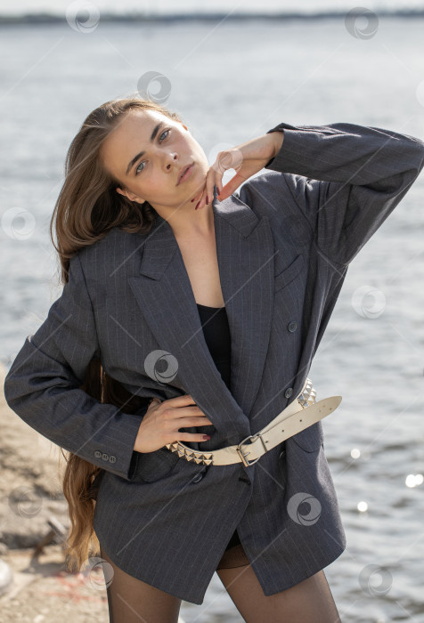 Скачать Портрет молодой брюнетки в полный рост в строгом пиджаке и черных колготках фотосток Ozero