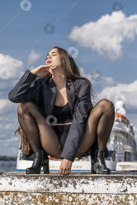 Скачать Портрет молодой брюнетки в полный рост в строгом пиджаке и черных колготках фотосток Ozero