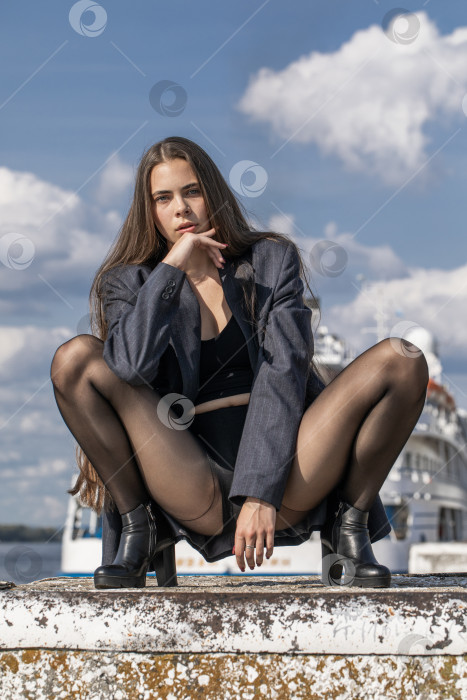 Скачать Портрет молодой брюнетки в полный рост в строгом пиджаке и черных колготках фотосток Ozero