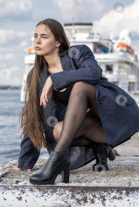 Скачать Портрет молодой брюнетки в полный рост в строгом пиджаке и черных колготках фотосток Ozero