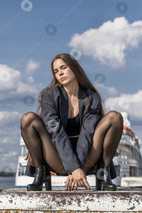 Скачать Портрет молодой брюнетки в полный рост в строгом пиджаке и черных колготках фотосток Ozero