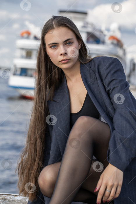 Скачать Портрет молодой брюнетки в полный рост в строгом пиджаке и черных колготках фотосток Ozero