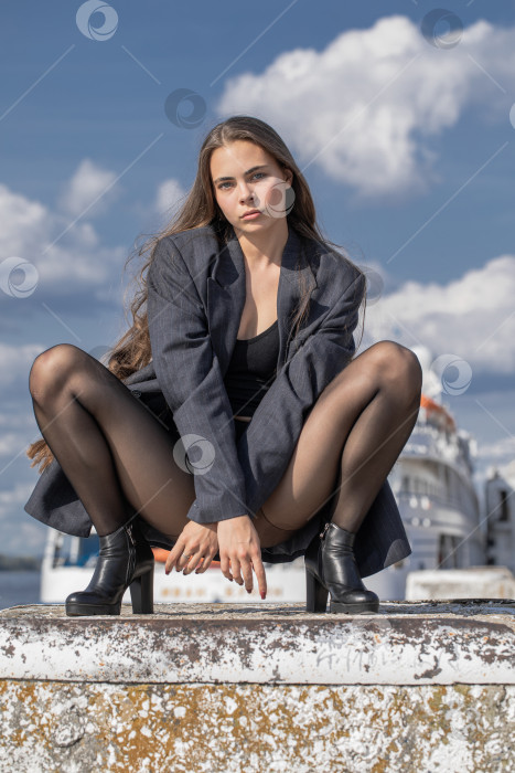 Скачать Портрет молодой брюнетки в полный рост в строгом пиджаке и черных колготках фотосток Ozero