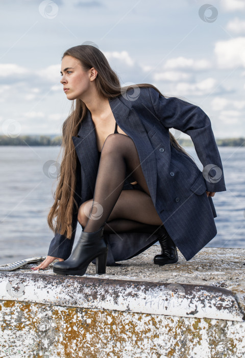 Скачать Портрет молодой брюнетки в полный рост в строгом пиджаке и черных колготках фотосток Ozero