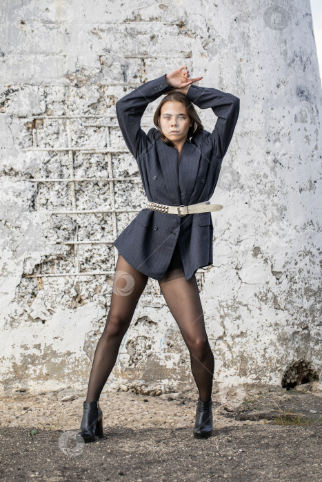 Скачать Портрет молодой брюнетки в полный рост в строгом пиджаке и черных колготках фотосток Ozero