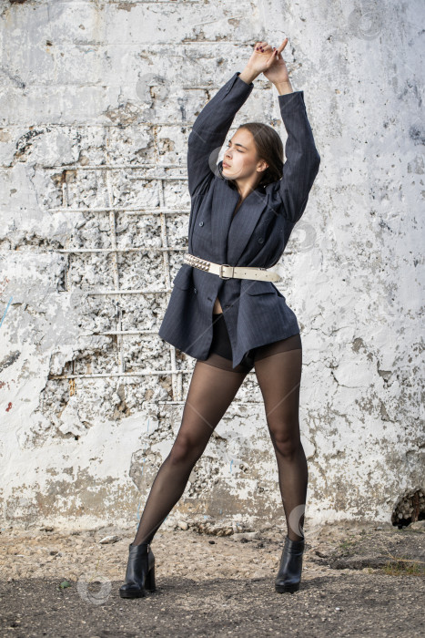 Скачать Портрет молодой брюнетки в полный рост в строгом пиджаке и черных колготках фотосток Ozero