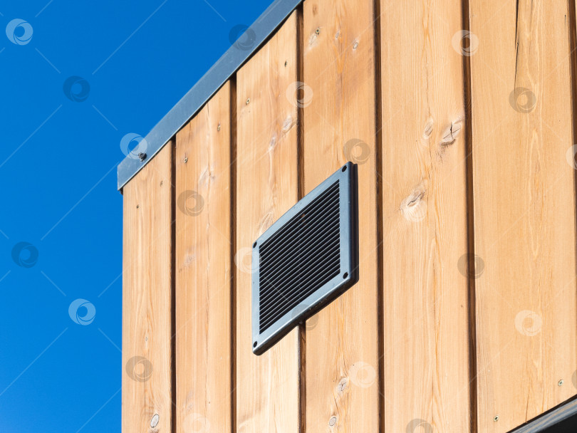 Скачать черное вентиляционное покрытие на деревянном фасаде дома в солнечный день фотосток Ozero