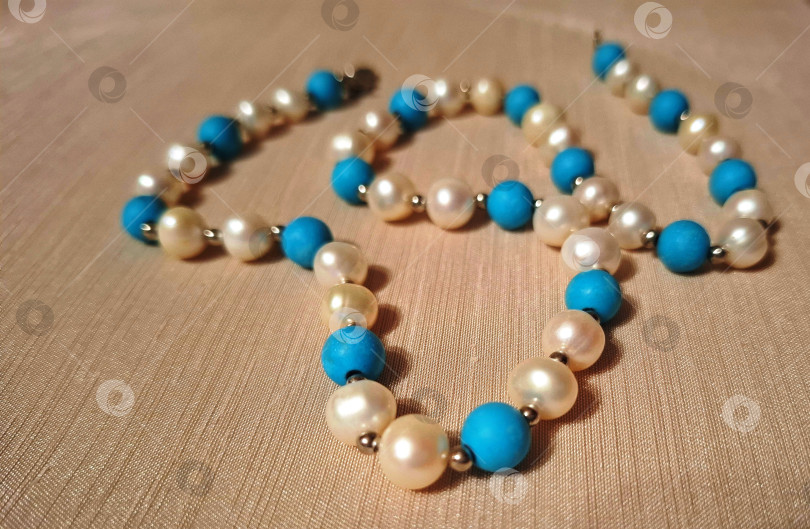 Скачать Нить с круглыми бусинами белого жемчуга и натурального камня бирюзы фотосток Ozero