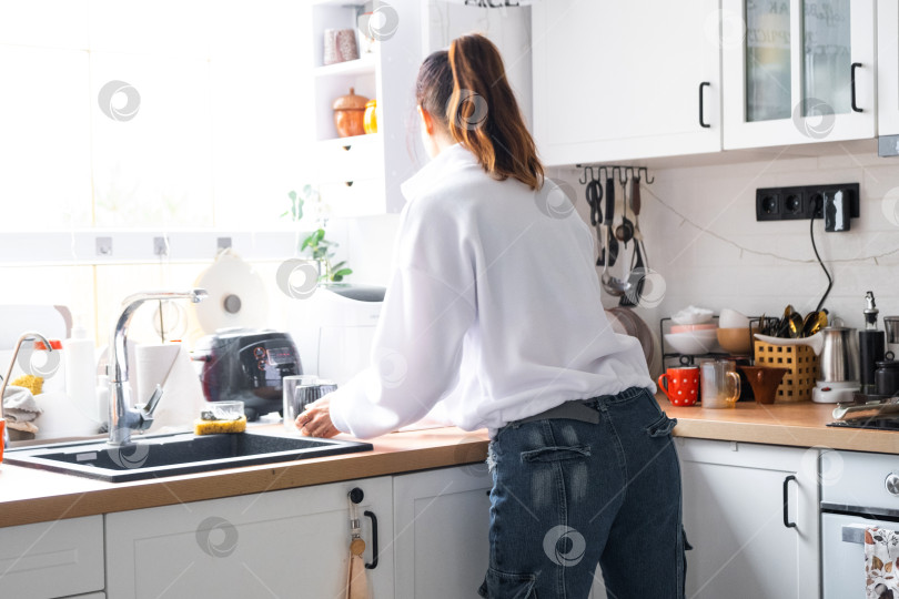 Скачать Женщина готовит и убирает на кухне фотосток Ozero