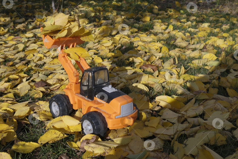 Скачать Фронтальный погрузчик на погрузке опавшей листвы. Детская игрушка фотосток Ozero