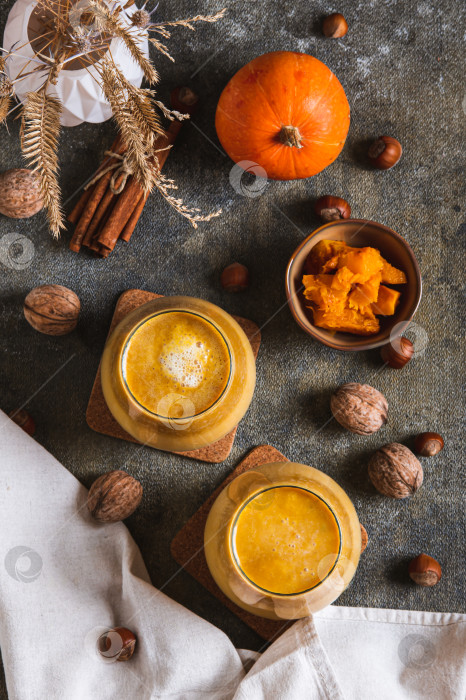 Скачать Осенний латте с тыквенным пюре, орехами и корицей в бокалах на столешнице в вертикальном положении фотосток Ozero