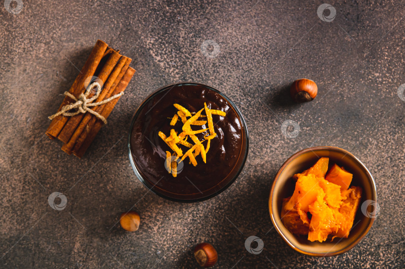 Скачать Шоколадно-тыквенный мусс с апельсиновой цедрой крупным планом в бокалах на столе, вид сверху фотосток Ozero