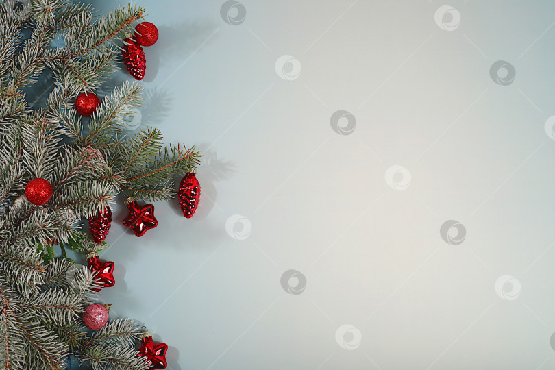 Скачать Красивый рождественский и новогодний фон с живыми заснеженными еловыми ветками, украшениями и игрушками, дизайн продукции для праздничной рекламы, концепция Сочельника, праздничная зимняя открытка и баннер на экране, фотосток Ozero