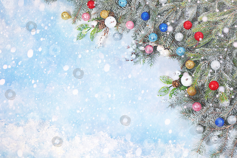 Скачать Красивый рождественский и новогодний фон с живыми заснеженными еловыми ветками, украшениями и игрушками, дизайн продукции для праздничной рекламы, концепция Сочельника, праздничная зимняя открытка и баннер на экране, фотосток Ozero