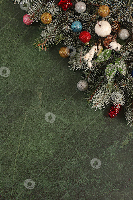 Скачать Красивый рождественский и новогодний фон с живыми заснеженными еловыми ветками, украшениями и игрушками, дизайн продукции для праздничной рекламы, концепция Сочельника, праздничная зимняя открытка и баннер на экране, фотосток Ozero