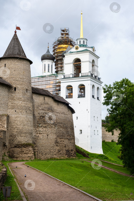 Скачать Псков, Псковская область, Россия - 7 августа 2025 года. Вид на стену и башню Псковского Кремля под облачным небом. фотосток Ozero