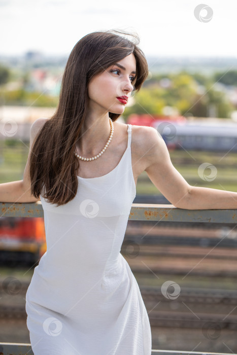 Скачать Портрет молодой красивой брюнетки в белом платье фотосток Ozero