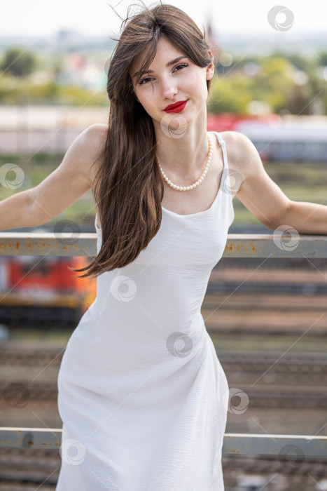 Скачать Портрет молодой красивой брюнетки в белом платье фотосток Ozero