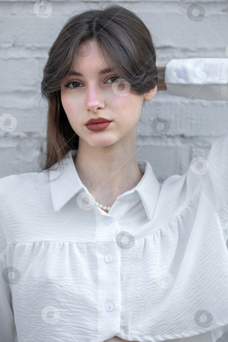 Скачать Портрет молодой красивой брюнетки крупным планом в белой блузке фотосток Ozero