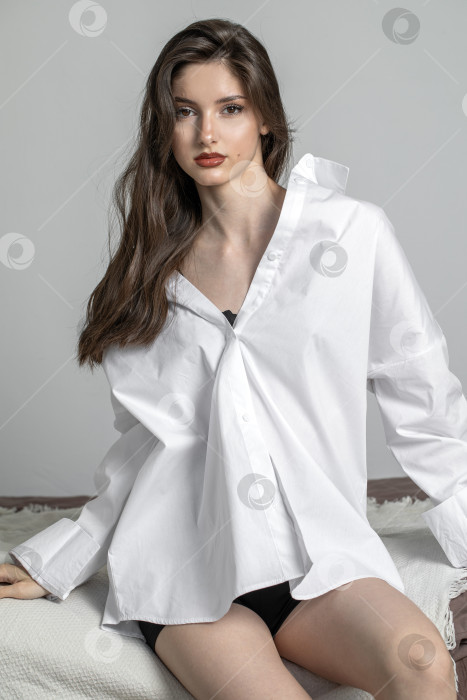 Скачать Портрет молодой красивой брюнетки-модели в белой рубашке фотосток Ozero
