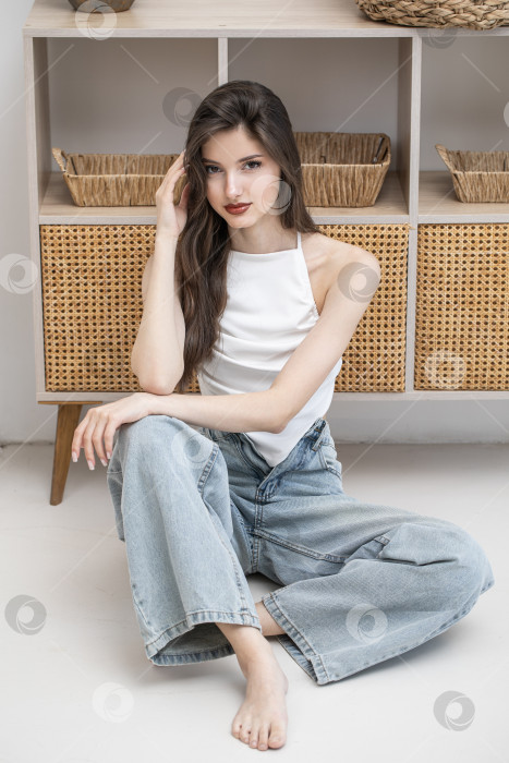 Скачать Модный портрет молодой красивой брюнетки в синих джинсах фотосток Ozero