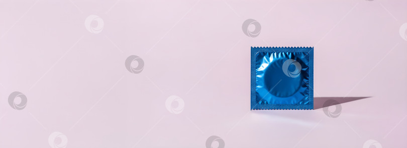 Скачать Голубая упаковка презервативов с выделенным местом для копирования на лавандовом фоне. Концепция баннера "Безопасный секс и сексуальное здоровье", посвященного дню контрацепции и профилактике заболеваний, передающихся половым путем. фотосток Ozero