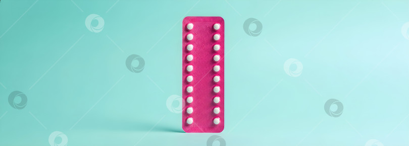 Скачать Розовая блистерная упаковка с оральными контрацептивами на синем фоне, символизирующая планирование семьи и репродуктивное здоровье. Шаблон "Месяц контрацепции и выбор женщин". фотосток Ozero