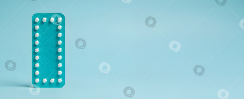 Скачать Синяя блистерная упаковка с белыми оральными контрацептивами на синем фоне, символизирующими планирование семьи и репродуктивное здоровье. Баннер "Месяц контрацепции" и "Выбор женщин". фотосток Ozero