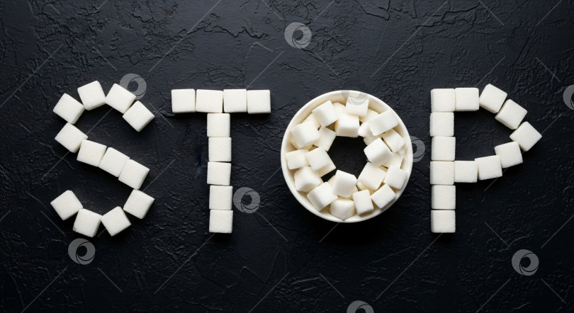 Скачать Надпись "Стоп", сделанная из кубиков белого сахара на темном фоне, - шаблон баннера для распространения информации о здоровом питании или концепции контроля диеты с помощью copyspace. Здоровая концепция профилактики диабета. фотосток Ozero