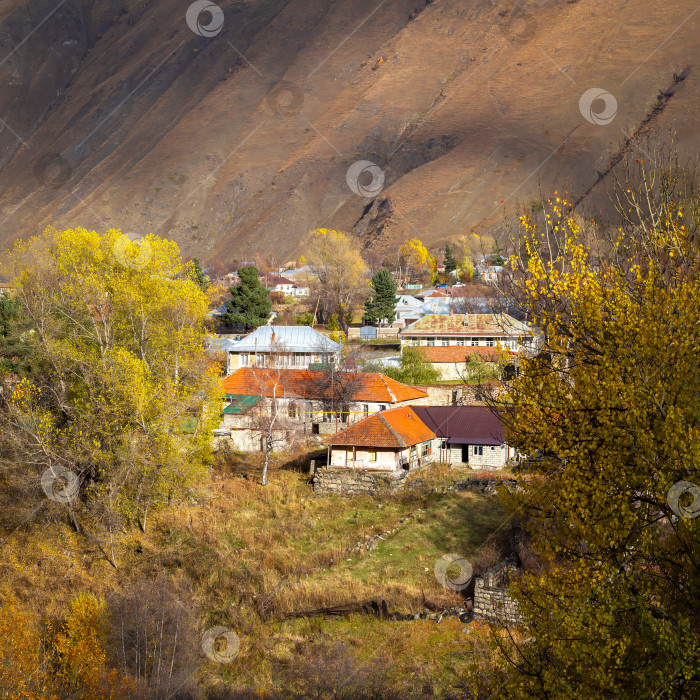 Скачать Степанцминда, окруженная золотыми осенними деревьями. Осень в Грузии. фотосток Ozero