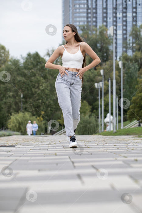 Скачать Молодая красивая брюнетка прогуливается по набережной фотосток Ozero