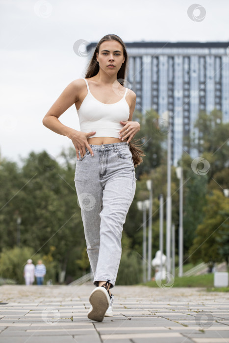 Скачать Молодая красивая брюнетка прогуливается по набережной фотосток Ozero
