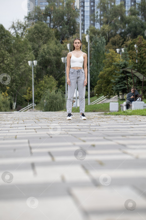 Скачать Портрет красивой молодой девушки в полный рост в серых джинсах фотосток Ozero