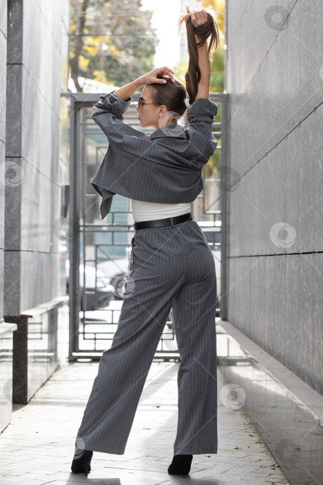 Скачать Деловая женщина позирует в брючном костюме фотосток Ozero