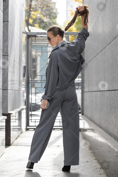 Скачать Деловая женщина позирует в брючном костюме фотосток Ozero