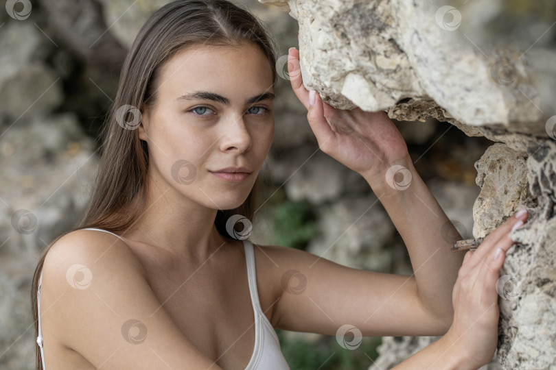 Скачать Молодая красивая женщина в белом топе позирует на скалах в горах фотосток Ozero