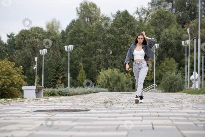 Скачать Молодая красивая брюнетка прогуливается по набережной фотосток Ozero