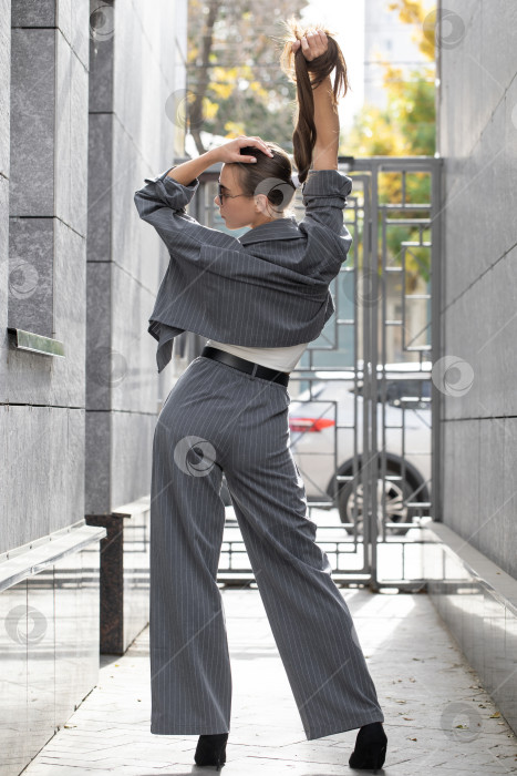 Скачать Деловая женщина позирует в брючном костюме фотосток Ozero