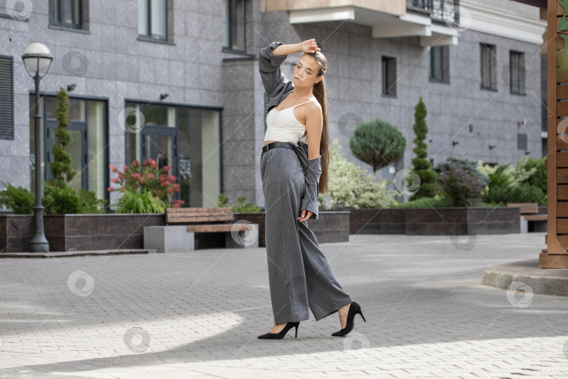 Скачать Деловая женщина позирует в брючном костюме фотосток Ozero