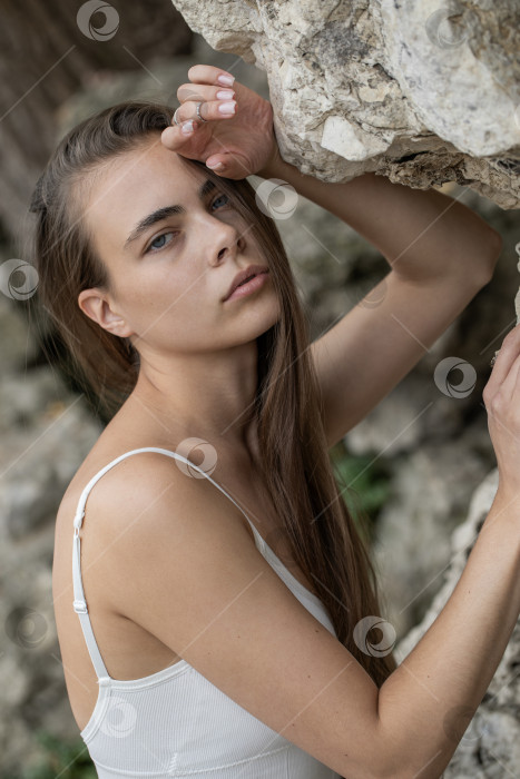 Скачать Молодая красивая женщина в белом топе позирует на скалах в горах фотосток Ozero