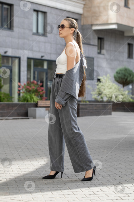 Скачать Деловая женщина позирует в брючном костюме фотосток Ozero