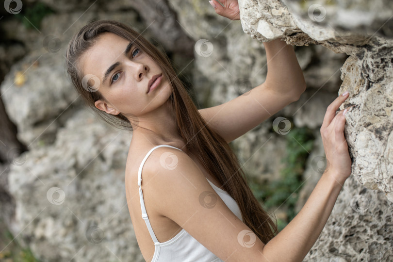 Скачать Молодая красивая женщина в белом топе позирует на скалах в горах фотосток Ozero