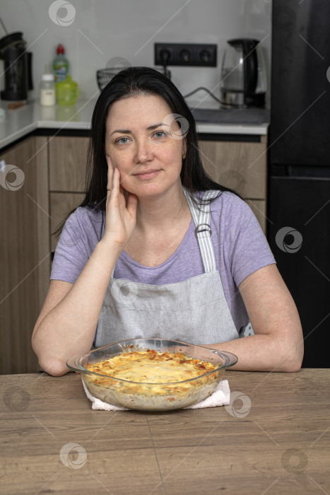 Скачать Портрет брюнетки средних лет на кухне в фартуке фотосток Ozero